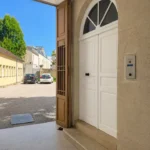 Entrée de l'immeuble de La Suite Devosge à Dijon avec porte d'accès et interphone