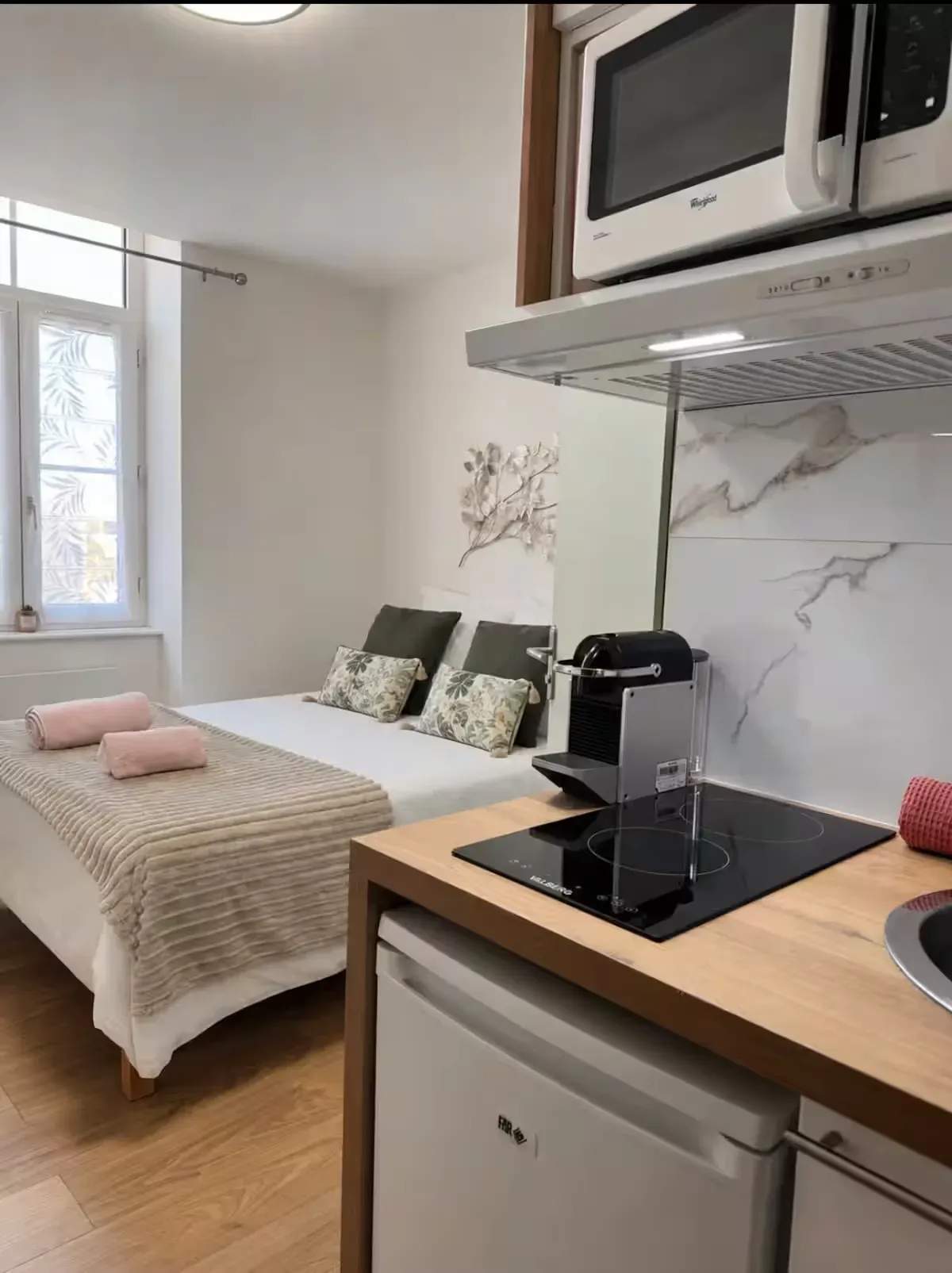 Studio ouvert de La Suite Devosge à Dijon avec espace nuit et coin cuisine équipé côte à côte