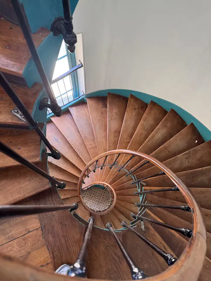 Escalier en colimaçon en bois de l'immeuble ancien où se trouve La Suite Devosge à Dijon