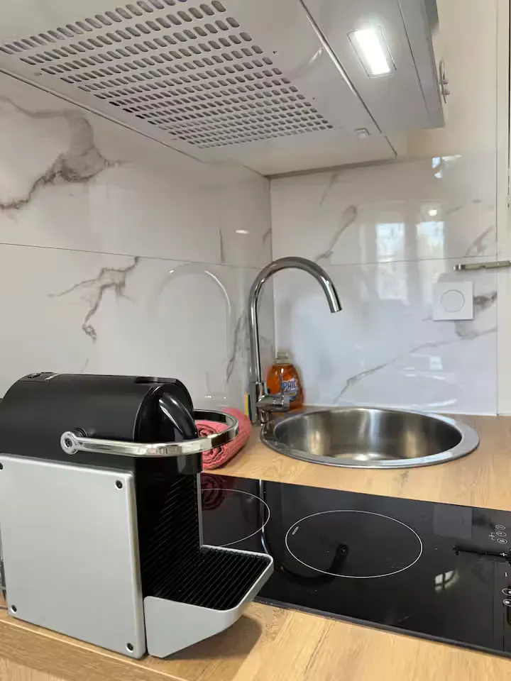 Détail du plan de travail cuisine de La Suite Devosge à Dijon : machine à café, plaque à induction et évier