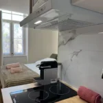 Coin cuisine équipé de La Suite Devosge à Dijon avec plaque à induction, hotte et machine à café